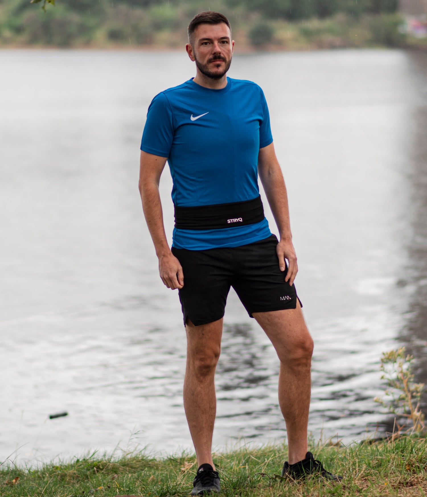 Man Posing on a river wearing the stryq running gear