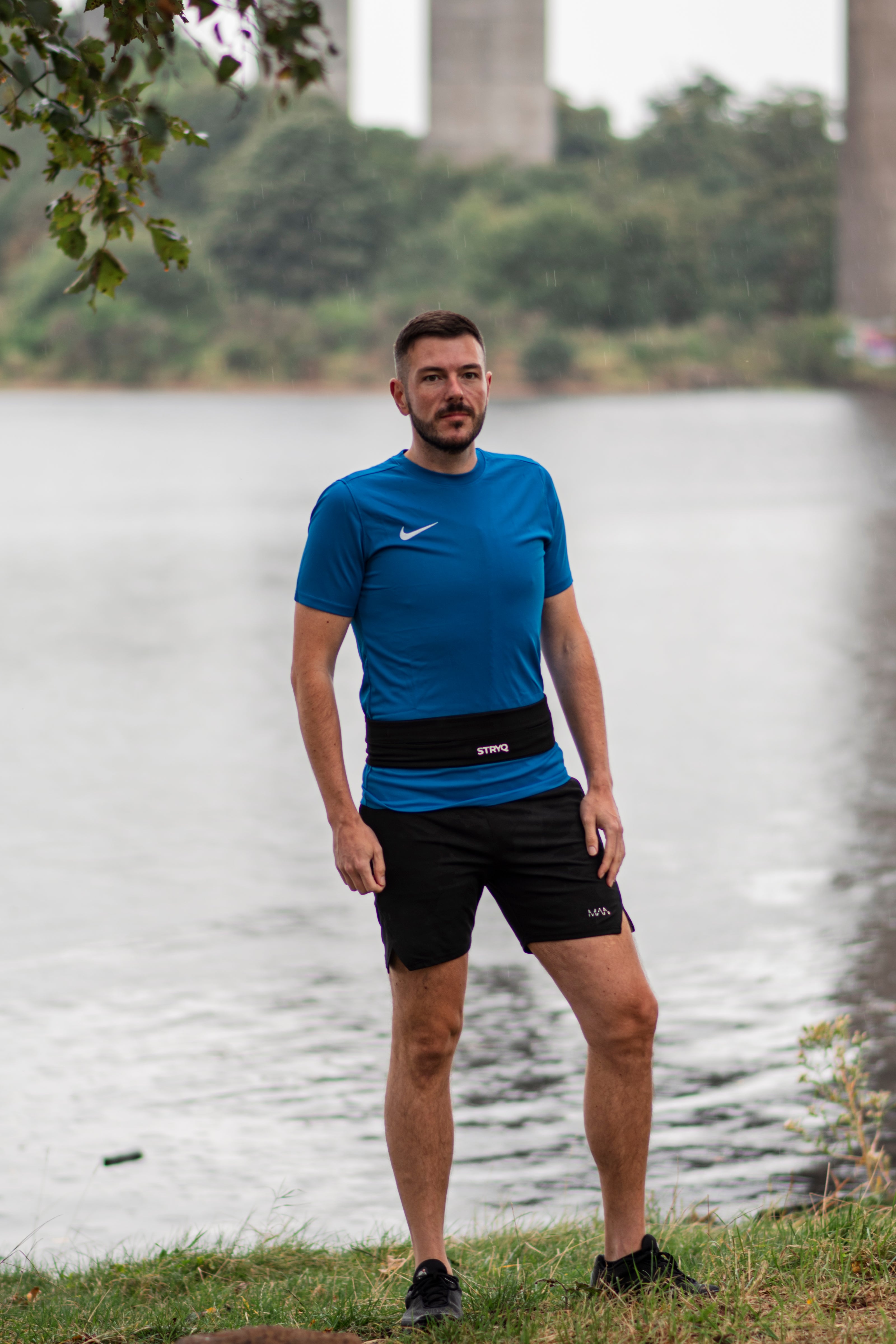 Man Posing on a river wearing the stryq running gear