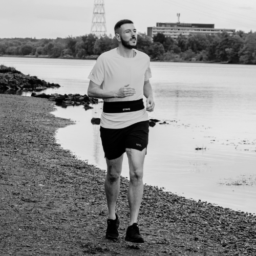 Running belt fit guide showing a STRYQ running belt at belly button level