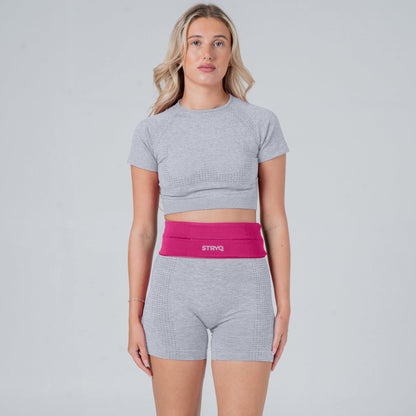 Runner wearing a pink waist pack in photoshoot